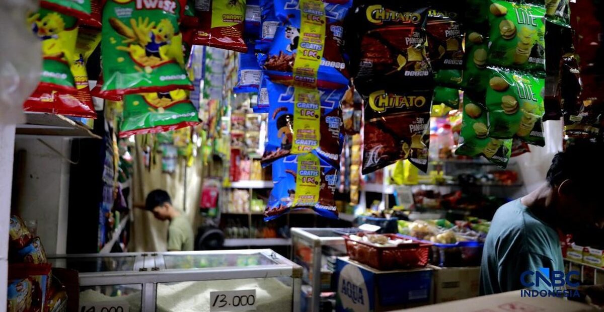 Ahmad menata barang dagangan di warung kecil di Jakarta