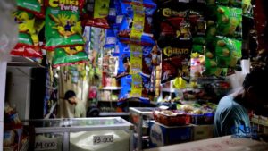 Ahmad menata barang dagangan di warung kecil di Jakarta
